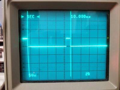 Photo of an analog oscilloscope screen showing a square wave with 10 ms period and a low duty cycle.