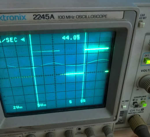 Oscilloscope screen with two patterns: a 0-5V/44Hz square wave and a ~1.5-2.5V/44Hz approximately sinusoidal wave.